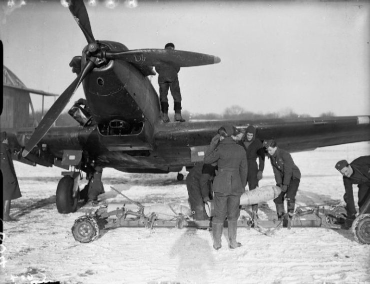 Royal Air Force- France 1939-1940. Armourers unloading 250-lb GP bombs from a trolley in front of a Fairey Battle of No. 226 Squadron, in the snow at Reims-Champagne.