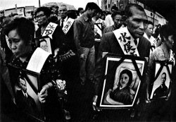 Minamata patients and family members hold photographs of their dead during a demonstration
