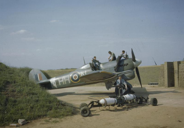 A Hawker Typhoon Mark IB of No 175 Squadron, Royal Air Force, undergoing servicing.Two dummy bombs for practice loading on to the wing racks can be seen in the foreground.