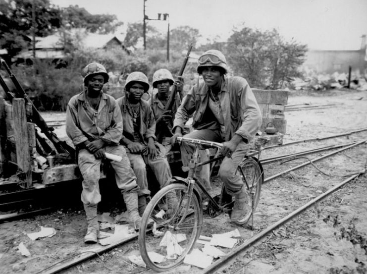 Members of the 3d Ammunition Company, part of the 2nd Marine Division, relax with a captured bicycle