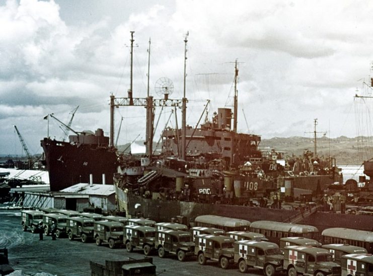 The U.S. Navy seaplane tender USS St. George (AV-16) at Guam, on 8 August 1945. The ambulances in the foreground are awaiting the arrival of the hospital ship USS Tranquillity (AH-14) with survivors of the sunken heavy cruiser USS Indianapolis (CA-35).