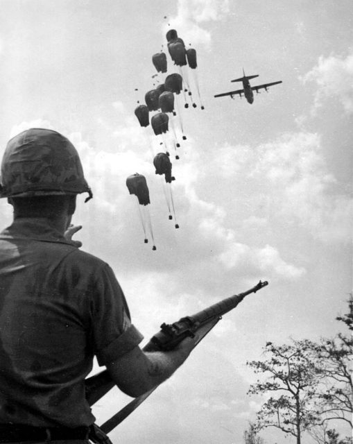 A U.S. soldier with an M14 watches as supplies are dropped in Vietnam, 1967.