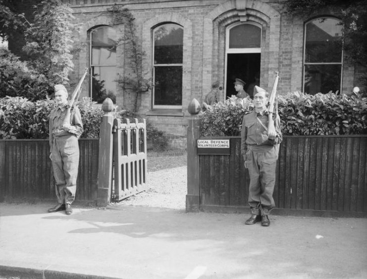 Members of the Local Defence Volunteers (LDV) armed with rifles outside their headquarters at Buckhurst Hill, Essex, 1 July 1940.