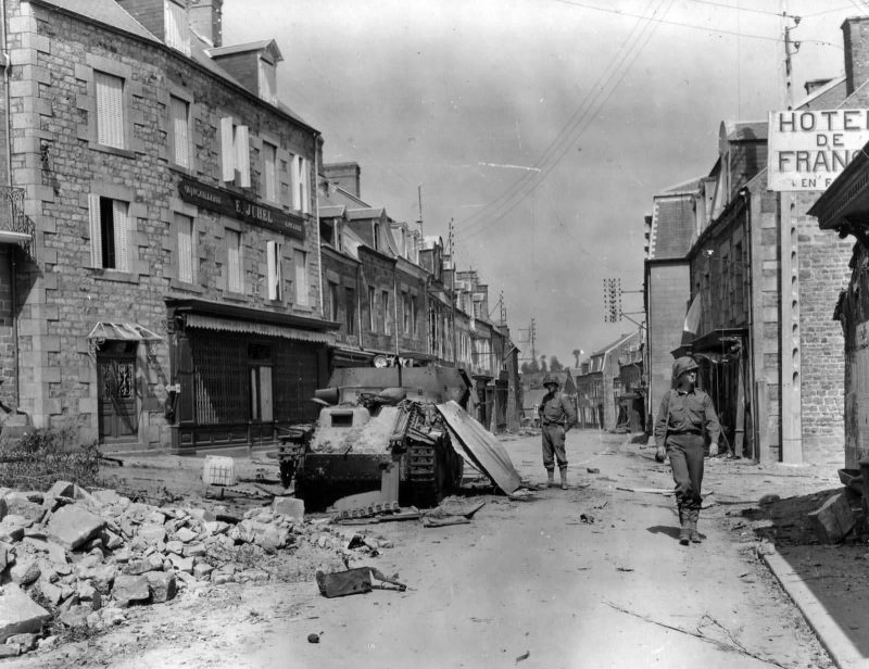 35th_Infantry_Division_Troops_And_Wrecked_Flakpanzer_38t_In_Tessy_Sur_Vire_France