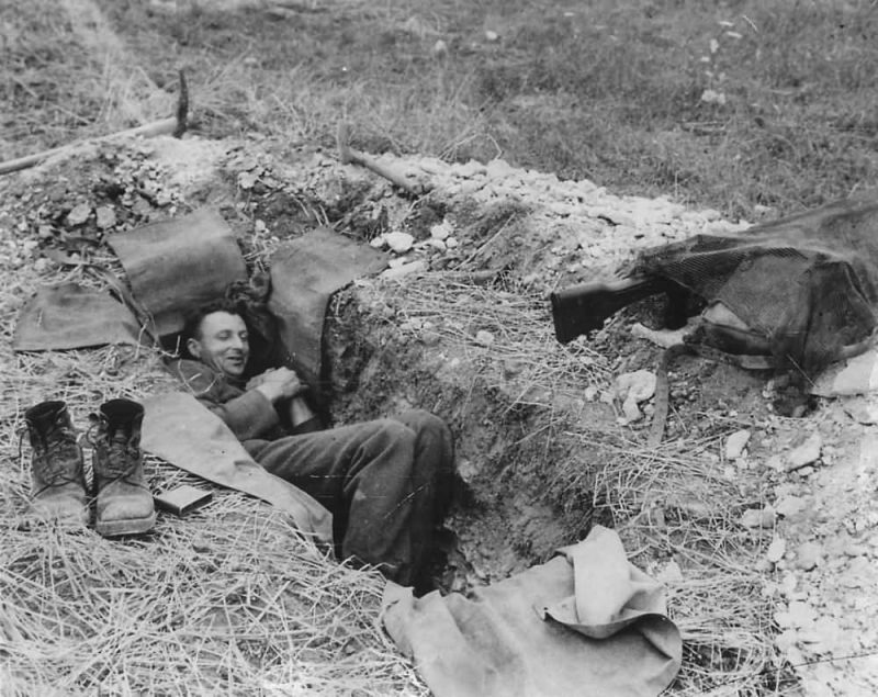 Canadian_Soldier_Resting_in_Foxhole_in_Normandy_France_1944