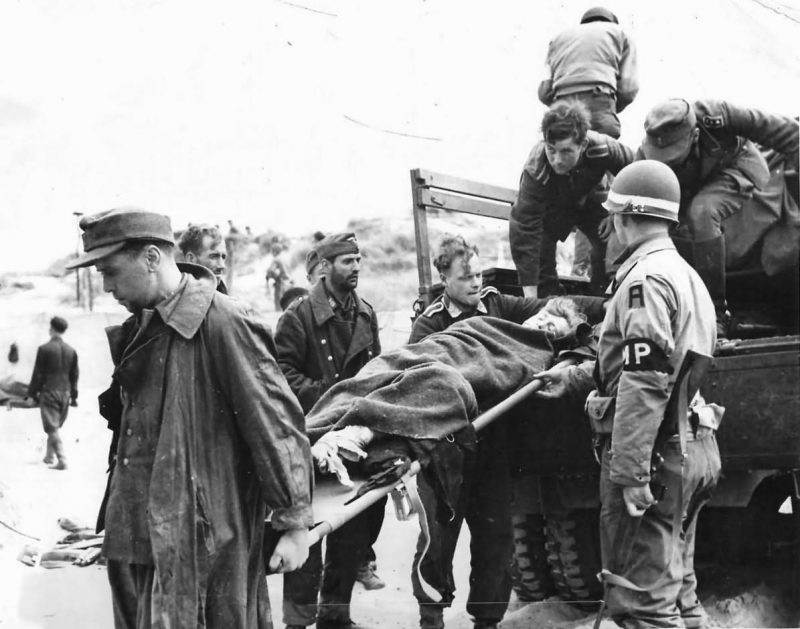 German_Prisoners_Unload_Wounded_Comrade_on_Normandy_Beachhead_1944