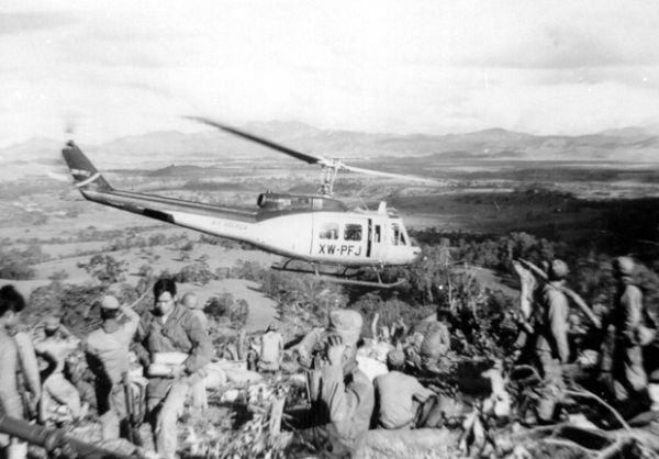 Air America Bell 205 helicopter leaving a Hmong fire support base in the Laotian Plain of Jars, c. 1969 (Wikipedia)