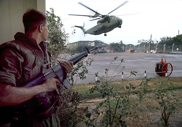US Marine Private First Class Forrest M. Turner, Jr. covering a Sikorsky CH-53 helicopter landing at the Defense Attaché Office compound in Saigon on 29 April 1975
