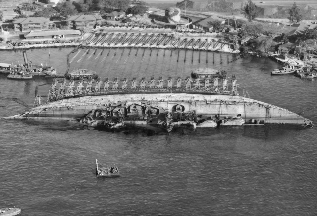 USS Oklahoma - An aerial view of salvage operations on 19 March 1943, looking toward Ford Island, with ship in 90 degree position.