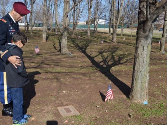 Chief Warrant Officer 2 Mickael Cruz and his son Joshua look at the Gander memorial tree for Cruz’s father, Staff Sgt. Francisco Cruz Salgado, who was among 248 Soldiers who died in a plane crash in Gander, Newfoundland, Dec. 12, 1985, while returning home from a peacekeeping mission in Egypt. (Photo: Sgt. 1st Class Eric R. Abendroth/Army) 