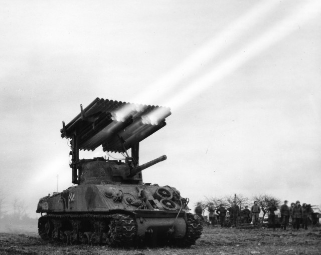Firing 4.5 inch rockets from M4-Sherman "Calliope" multiple rocket launcher, mounted on M-4, No. A-3 tank. 14th Armored, France.