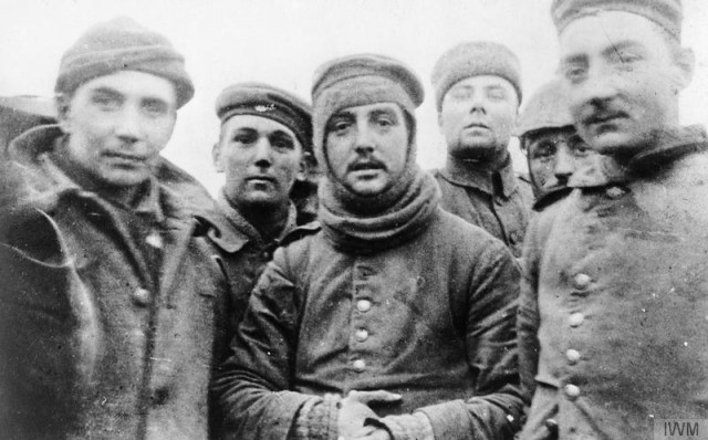 The German soldier in the middle is wearing a British balaclava, a gift from the British soldiers he is posing with