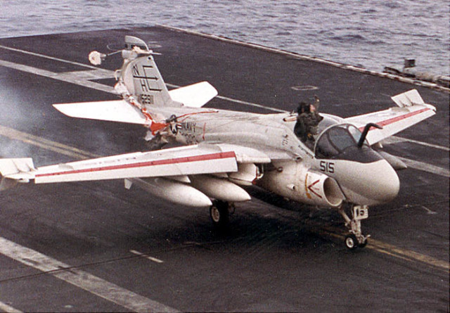 LT Keith Gallagher is seen above the canopy as the A-6 aircraft touches down on the deck of the Lincoln. Note that LT Gallagher's parachute has deployed and is wrapped around the tail of the aircraft.   (Navy photo) 