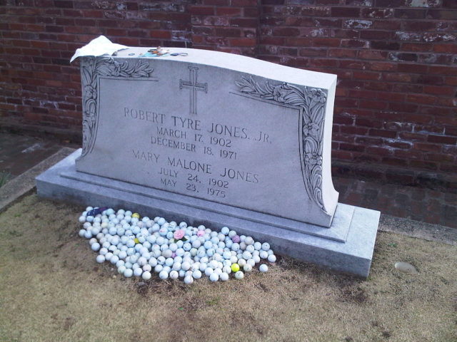 Jones' grave in Atlanta's Oakland Cemetery with putting green, golf balls, and mementos.