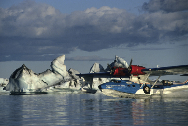 Iceland, Jokulsarlon lake, Catalina hydroplane landing amids icebergs