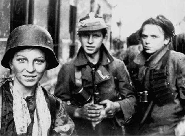 Boyscouts of the Warsaw Uprising, 1944. One of them is wearing a captured German helmet.