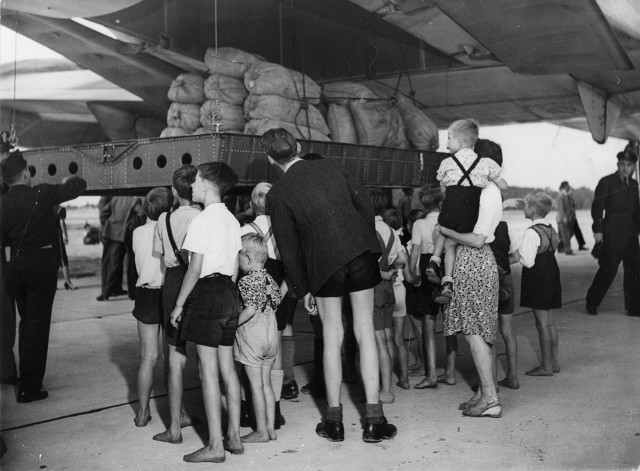 A U. S. Air Force C-74 Globemaster plane touched down at Gatow airfield located in southwestern Berlin, Germany on Tuesday with more than 20 tons of flour from the United States. “Operation Vittles” otherwise known as the Berlin Airlift (June 24, 1948-May 12, 1949) was a combined effort of the western allies against the Soviet Union’s blockade of all land routes into Berlin. The German children look on as the flour bags are lowered on August 19, 1948