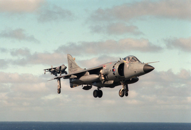 Two Royal Navy British Aerospace Sea Harrier FRS.1 from 800 Naval Air Squadron, assigned to the aircraft carrier HMS 'Illustrious (R06), approach the flight deck of the U.S. Navy aircraft carrier USS Dwight D. Eisenhower (CVN-69) (Public Domain / Wikipedia)
