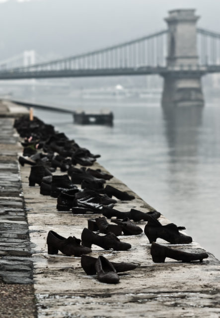 Scarpe sulla riva del Danubio memorial a Budapest, Ungheria. Onora gli ebrei e le altre vittime dei nazisti e la freccia Croce Photo Credit