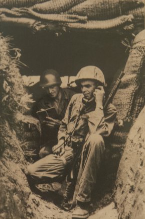 U.S. Army 2nd Lt. William H. Funchess (on radio) and Sgt. O.J. Mixon, both in the 19th Infantry Regiment, maintain cover in a bunker on the bank of the Kum River north of Taejon, South Korea, July, 1950. "That was my first engagement. There were 13 Russian T-34 tanks across the river firing point-blank into us." Funchess was captured on Nov. 4, 1950 after a fierce fight with an overwhelming Chinese force. He endured 34 months as a prisoner of war before finally being released on Sept. 6, 1953. Credit: Courtesy of William Funchess.