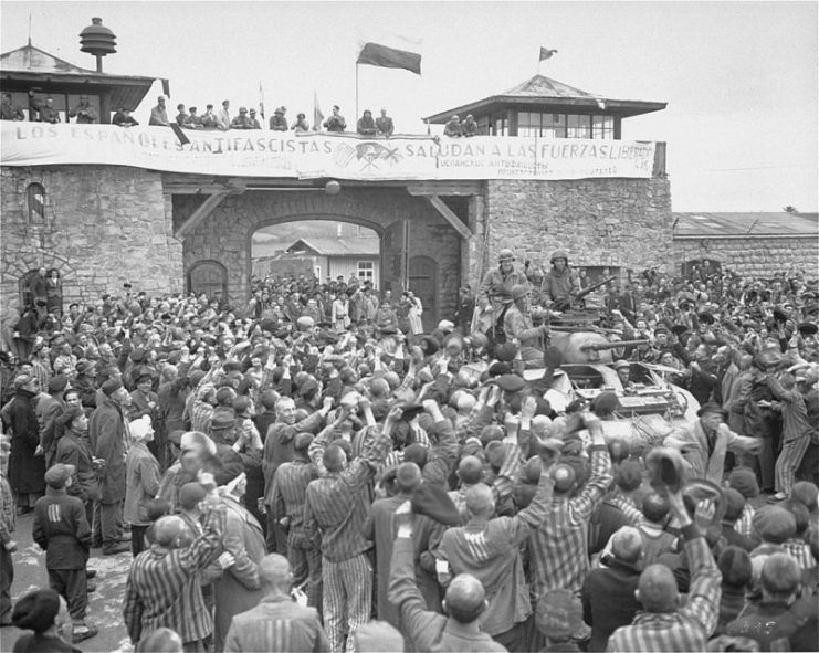 Mauthausen survivors cheer the soldiers of the Eleventh Armored Division of the U.S. Third Army one day after their actual liberation. The banner reads: “The Spanish Anti-Fascists Salute the Liberating Forces.”