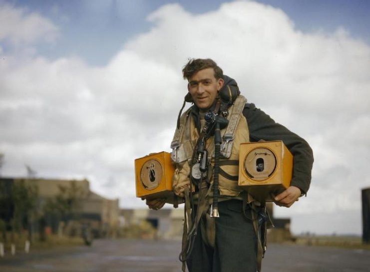 Canadian PO (A) S Jess, wireless operator of an Avro Lancaster bomber operating from Waddington, Lincolnshire carrying two pigeon boxes. Homing pigeons served as a means of communications in the event of a crash, ditching or radio failure.