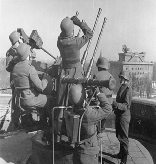 A gun crew on the Zoo Flak tower searching the sky for enemy aircraft. In the back ground the command tower which flanked each Flak tower. (Bundesarchiv, Bild 183-G1230-0502-004, Pilz / CC-BY-SA)