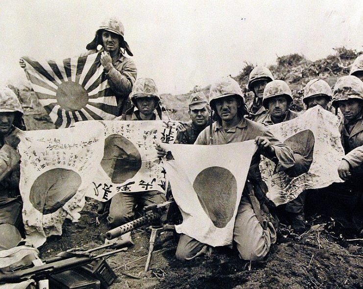 Fifth Division Marines grouped behind their light machine gun, display Japanese battle flags captured during the first few days of the bloody fight for Iwo Jima. It was the men of the Fifth Division who fought their way to the top of Mount Suribachi to raise the American flag on the rim of the crater.