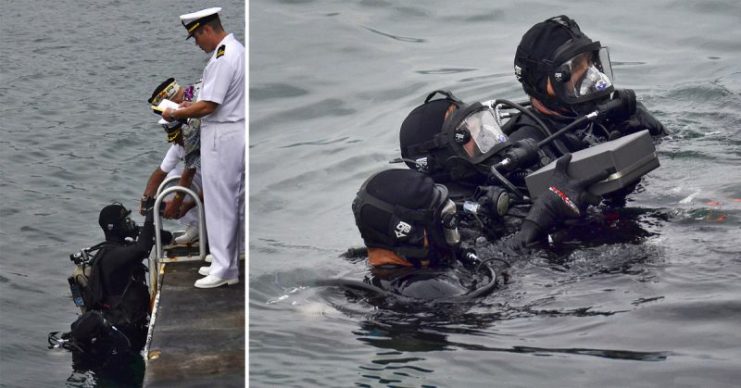 U.S. Navy Lt. Terry Bewley, a chaplain, reads a prayer while the remains of Seaman 1st Class Wallace F. Quillin are handed to National Park Service divers during an interment at the USS Arizona Memoria
