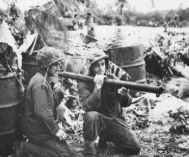 Displaying the bazooka which knocked out four Japanese light tanks are bazooka men PFC Lauren N. Kahn, left, and PFC Lewis M.