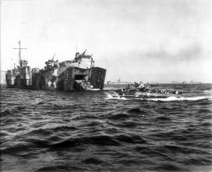 USS LSM-322 in the far background off Okinawa Beachhead on April 1st as a Coast Guard manned LST in the foreground launches a LVT-4 amphibious tractor