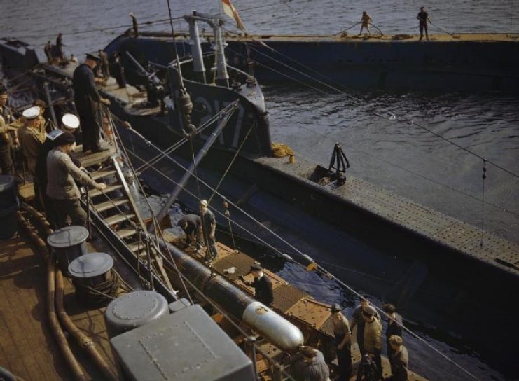 The depot ship HMS FORTH transferring a practice torpedo to the submarine P311.