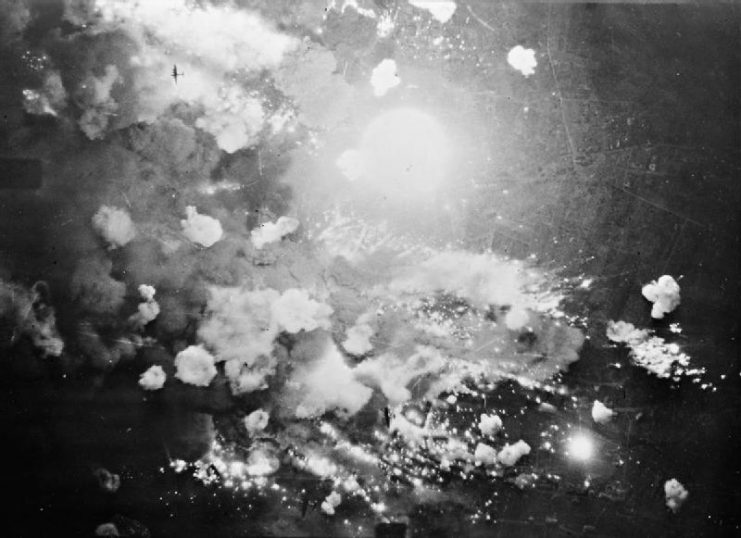 Vertical aerial photograph taken over Pforzheim, Germany, during the first and only area-bombing raid on the city. High explosive and incendiary bombs explode in the target area at the height of the attack.