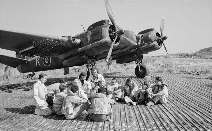 Aircrew of No. 16 Squadron SAAF and No. 227 Squadron RAF sitting in front of a Bristol Beaufighter at Biferno, Italy, prior to taking off to attack a German headquarters building in Dubrovnik, Yugoslavia, 14 August 1944.