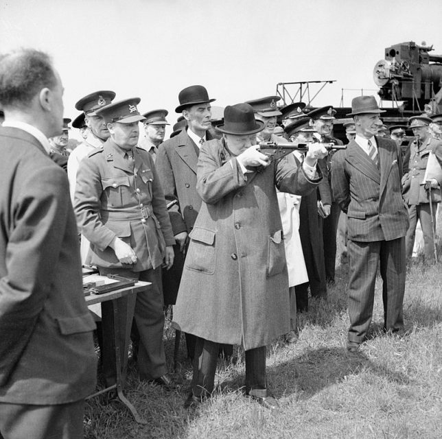 Churchill takes aim with a Sten submachine gun in June 1941. The man in the pin-striped suit and fedora to the right is his bodyguard, Walter H. Thompson.