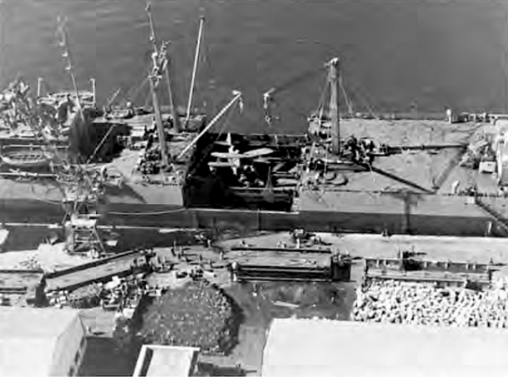 Lakehurst, formerly Seatrain New Jersey, loading damaged U.S. Navy scout plane after discharging medium tanks at Safi North Africa.