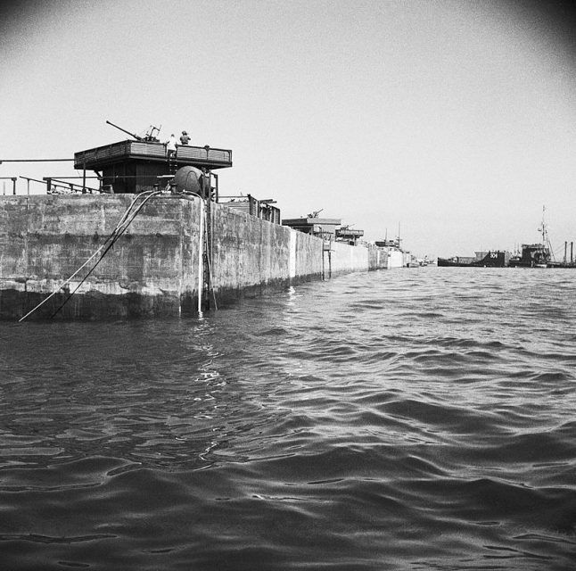 A line of Phoenix caissons in place at Arromanches, with anti-aircraft guns installed. 12 June 1944
