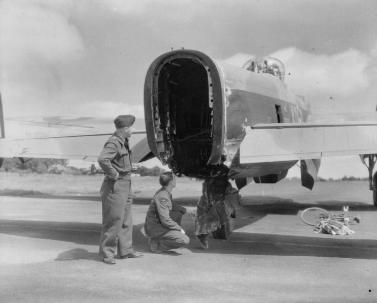 Crew members inspect the tail of a 115 Squadron Bomber.
