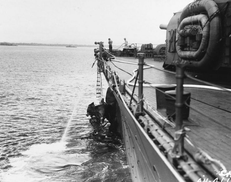 The U.S. Navy heavy cruiser USS Chicago (CA-29) off Guadalcanal the day after the Battle of Savo Island, showing crewmen cutting away damaged plating to enable the ship to get underway.