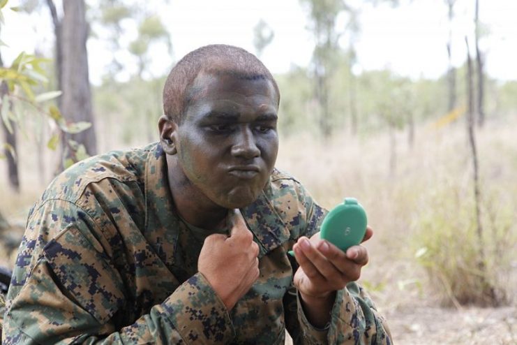 A US Marine applying camouflage paint