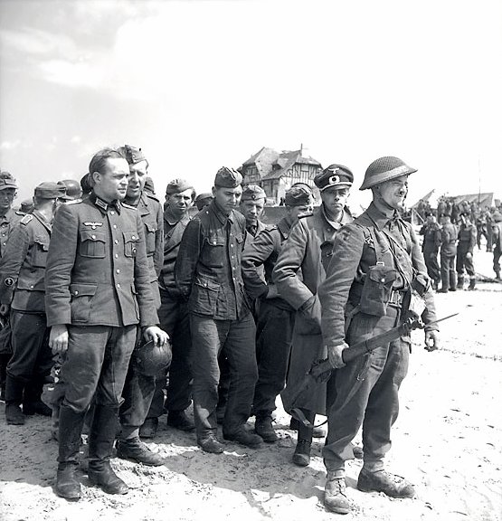 Allied soldiers guarding German prisoners on Juno