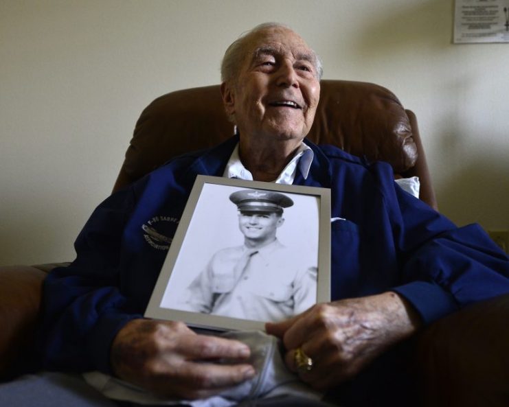 Retired Col. Ralph Parr holds a portrait of himself.