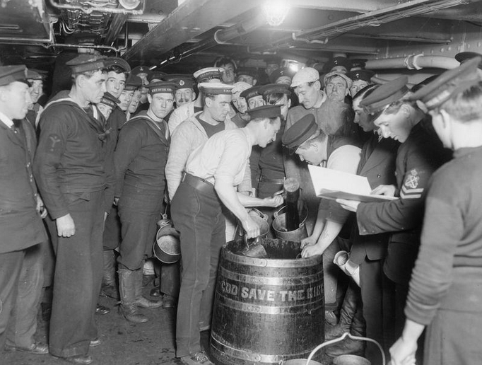 Royal Marines and bluejackets being served their rum rations on board HMS Royal Oak.