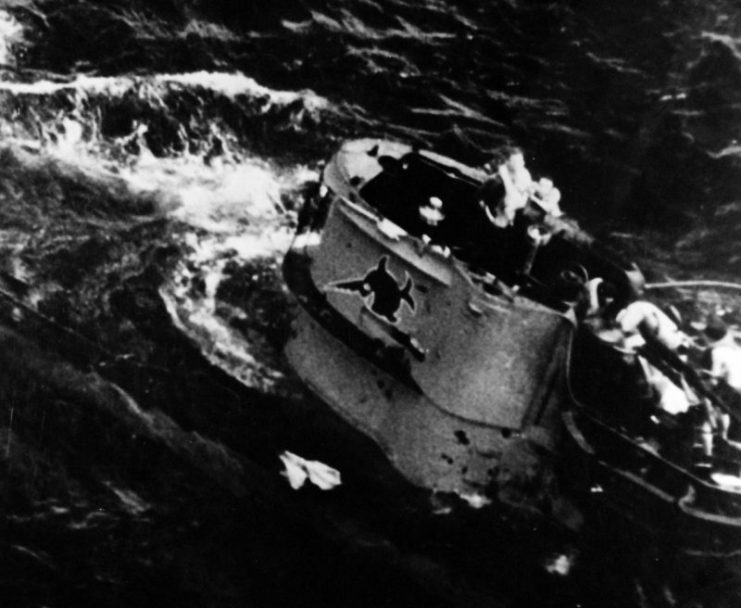 Caption: Air Attacks on German U-boats, WWII. Crew of German U-boat, U-664, prepare to go over side of ship during attack by two Avenger aircraft from USS Card (CVE-11), August 9, 1943. Note, the laughing sawfish insignia on the conning tower of the 9th U-boat Flotilla. Incident #3992. Official U.S. Navy Photograph, now in the collections of the National Archives. (2015/8/18