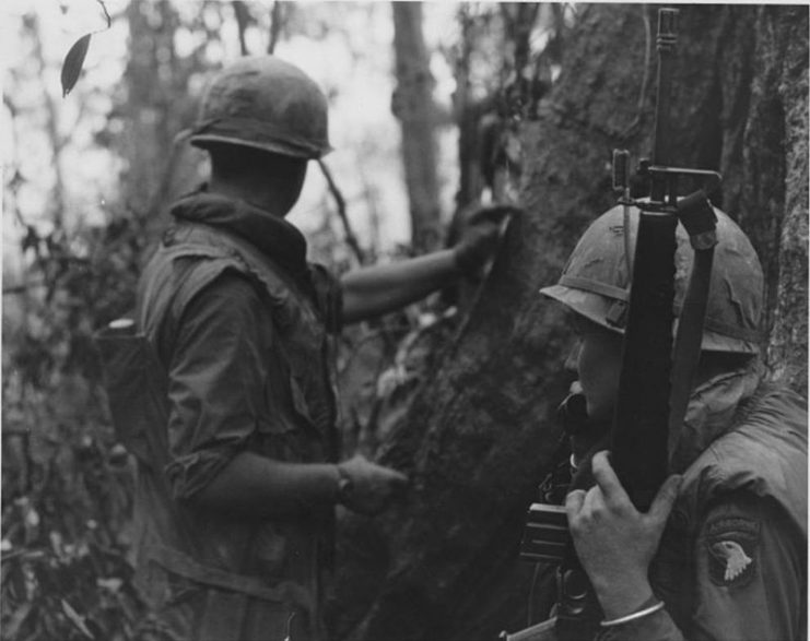 Troopers on patrol in Vietnam; radioing for communication.
