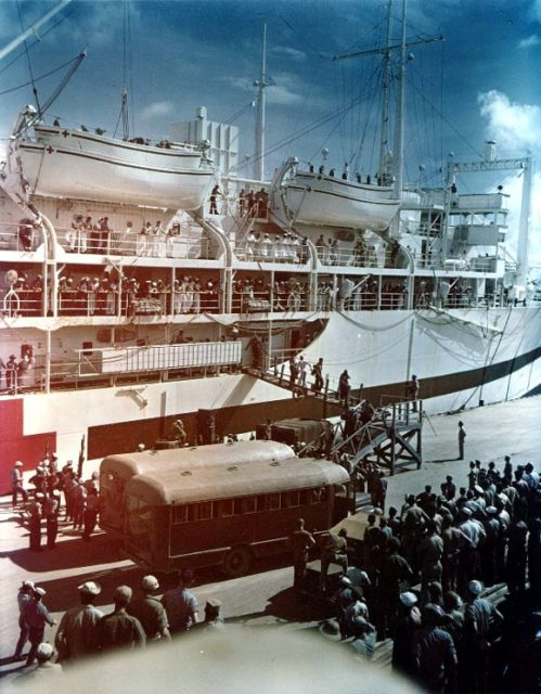 Survivors of the heavy cruiser USS Indianapolis (CA-35) are brought ashore from the U.S. Navy hospital ship USS Tranquillity (AH-14) at Guam, 8 August 1945.
