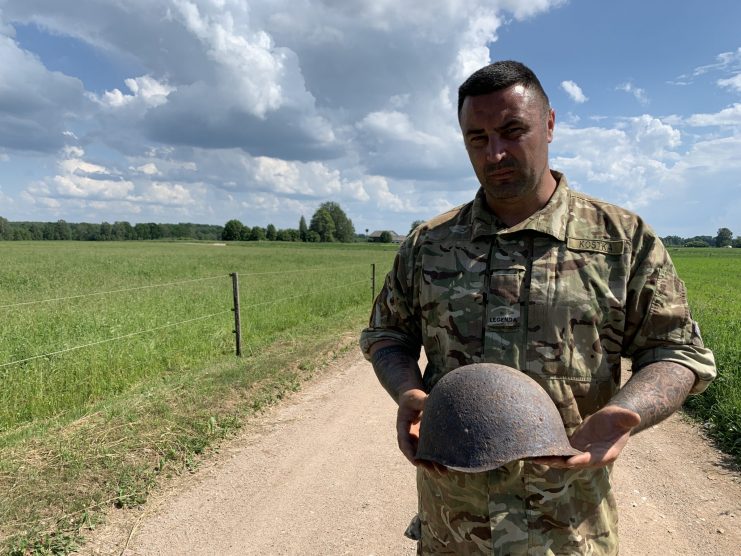 Gary Kostka holding a Soviet Helmet on the former battlefield. Found by a local farmer on his land. (Jonny Bay 2019)