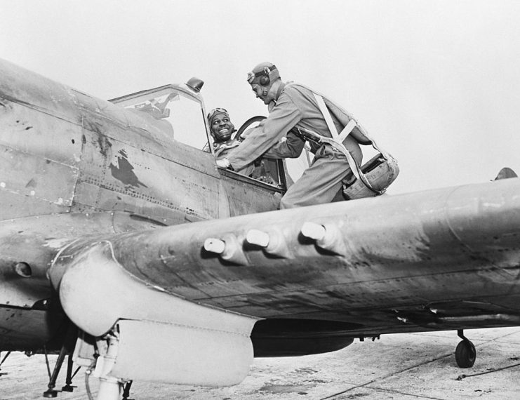 Lieutenant Colonel Benjamin Davis talks to Lieutenant Charles Dryden (in cockpit) before he takes off in a P-40 Warhawk at an army air base.