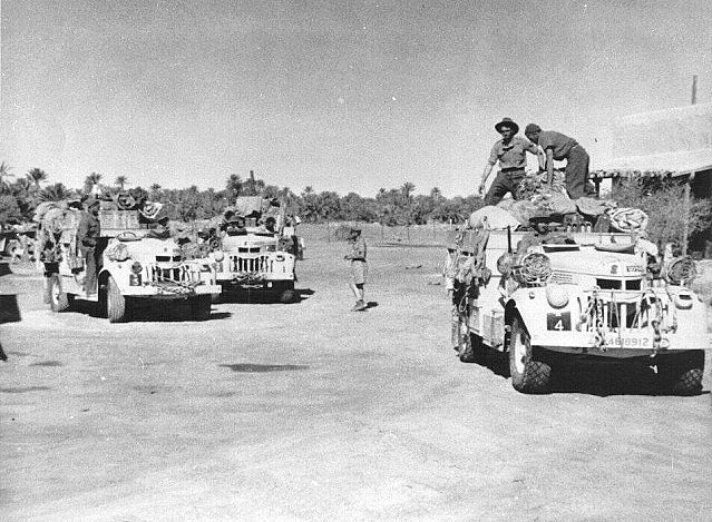 Heavily laden Chevrolets of ‘R1’ Patrol setting out from Jalo oasis in 1942. The unit insignia of a Māori Hei-Tiki can just be seen on the bonnet of the lead vehicle, which carries its individual number “R4” on a dark square on the right fender.