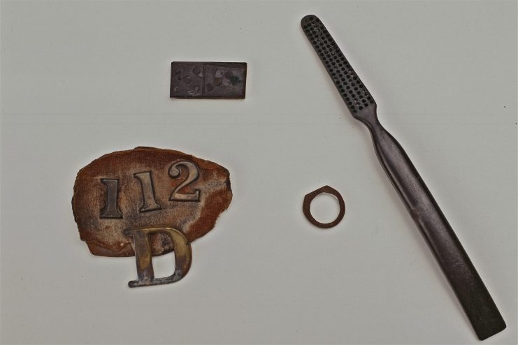 Personal items from 112th N.Y.S.V. company D soldier: domino, toothbrush, hand-carved wooden ring with initials.